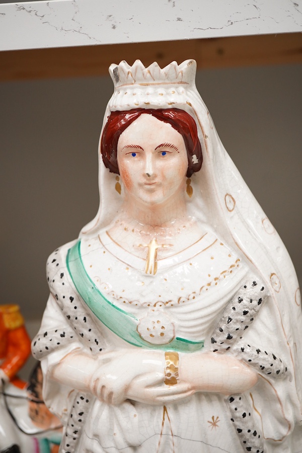 A collection of seven Staffordshire figures, including Queen Victoria - 45cm high, a cricketer, a boy reading, Tom King etc
